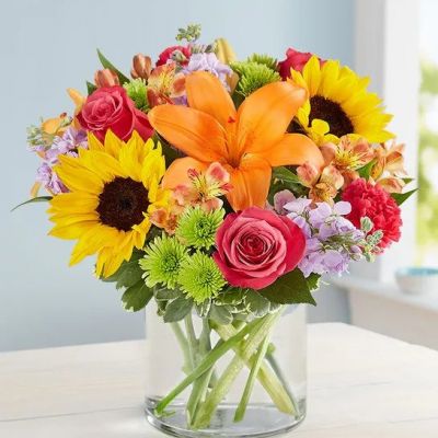 Like a warm embrace, our vibrant flower bouquet delivers your sentiments to someone special. A rich gathering of yellow and orange blooms, with pops of bright pink and purple, it's more than a gift - it's a way to express how you feel inside.