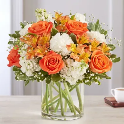 The sweet citrus shades in our charming bouquet bring your sentiments to life. Loosely gathered inside a clear cylinder vase, the mix of vibrant orange and creamy white blooms makes special milestones and everyday moments even more memorable.