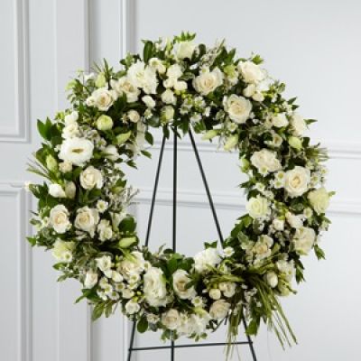 The FTD® Splendor™ Wreath is a symbol of lasting love and kinship, whether for the deceased or in comfort of those suffering from a loss. Elegant white freesia, double lisianthus, spray roses, monte casino asters and limonium are accented with a variety of lush greens and green raffia ribbon, perfectly arranged in the form of a wreath, to create a beautiful way to display your sincere sentiments.