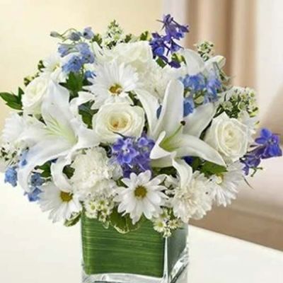 Send your best wishes with our blue and white Hope Floats arrangement. The freshest roses, delphinium, lilies, daisy poms and carnations are hand-designed in a stunning cube vase sure to wow and inspire your recipient.