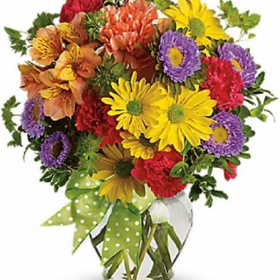 A summery mix of yellow daisy chrysanthemums, purple asters and red and orange carnations - arranged in a clear ginger vase and adorned with a cheerful green plaid bow - will make their wishes come true!
