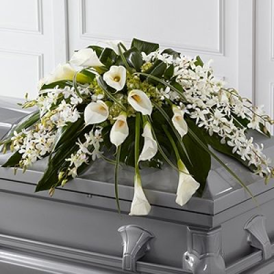 The FTD® Angel Wings™ Casket Spray is an exceptionally gorgeous way to bring peace and beauty to their final farewell service. White Dendrobium orchids, white calla lilies, green hydrangea and a variety of lush greens are artfully arranged to perfectly adorn the top of their casket, offering the colors and ambience of grace and serenity.